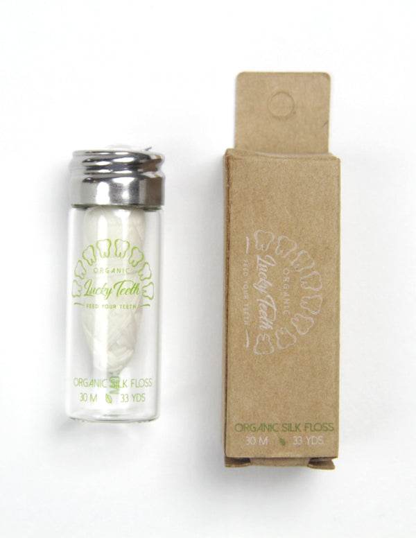 Clear container with silver cap and brown cardboard box on a white background