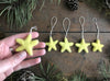 Mahonia Yellow wool star ornaments with cotton string loops, close-up view
