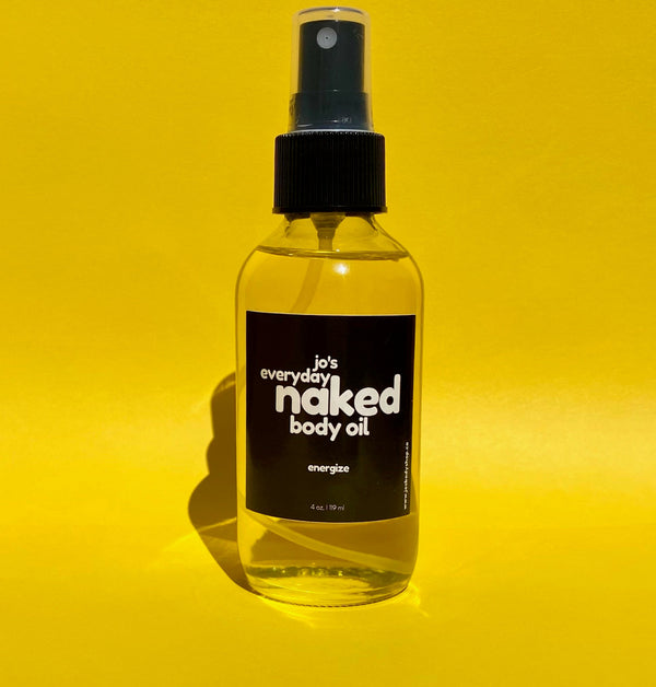 Bottle of Jo's Everyday Naked Body Oil on a yellow background