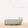 Ceramic pot on a beige surface with a white background