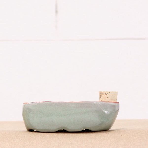 Ceramic pot on a beige surface with a white background