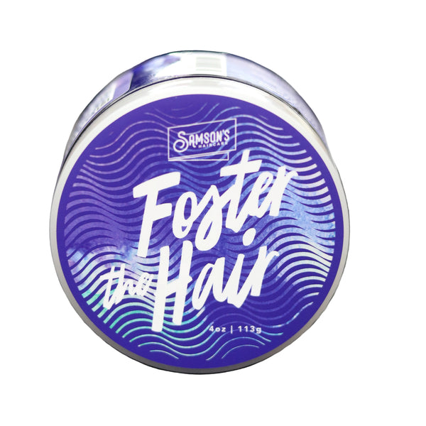 Blue container labeled 'Foster the Hair' on a textured surface with a blurred background. Achieve maximum hold and precision with Samson's Foster the Hair Gel Pomade. Perfect for braiding, waves, and edge control. 3% of proceeds support children in foster care. Shop high-performance, ethical grooming at Clozist!