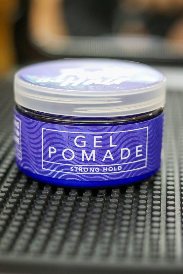 Jar of gel pomade with a blue label on a textured surface