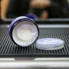 Open jar of hair product with lid on a textured surface, blurred person in the background