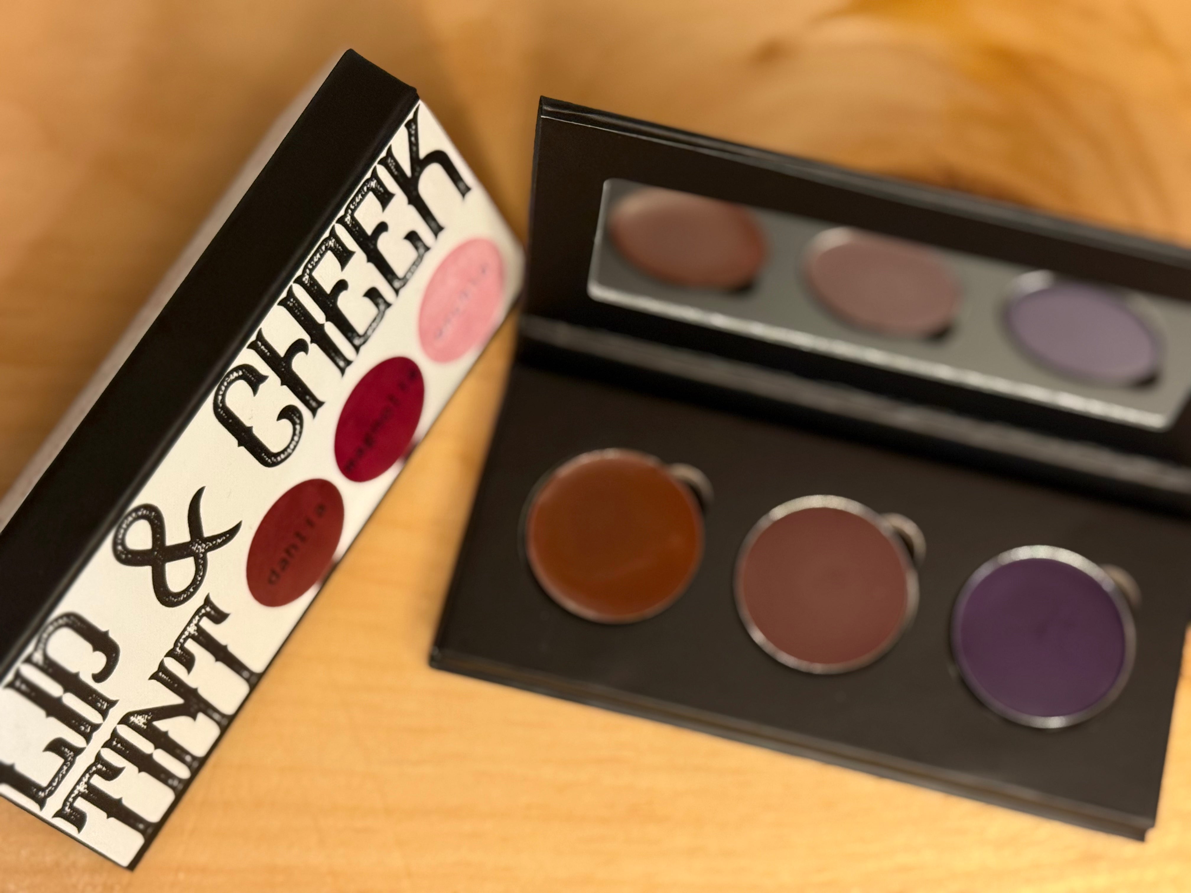 Makeup palette with lip tint and cheek products on a wooden surface