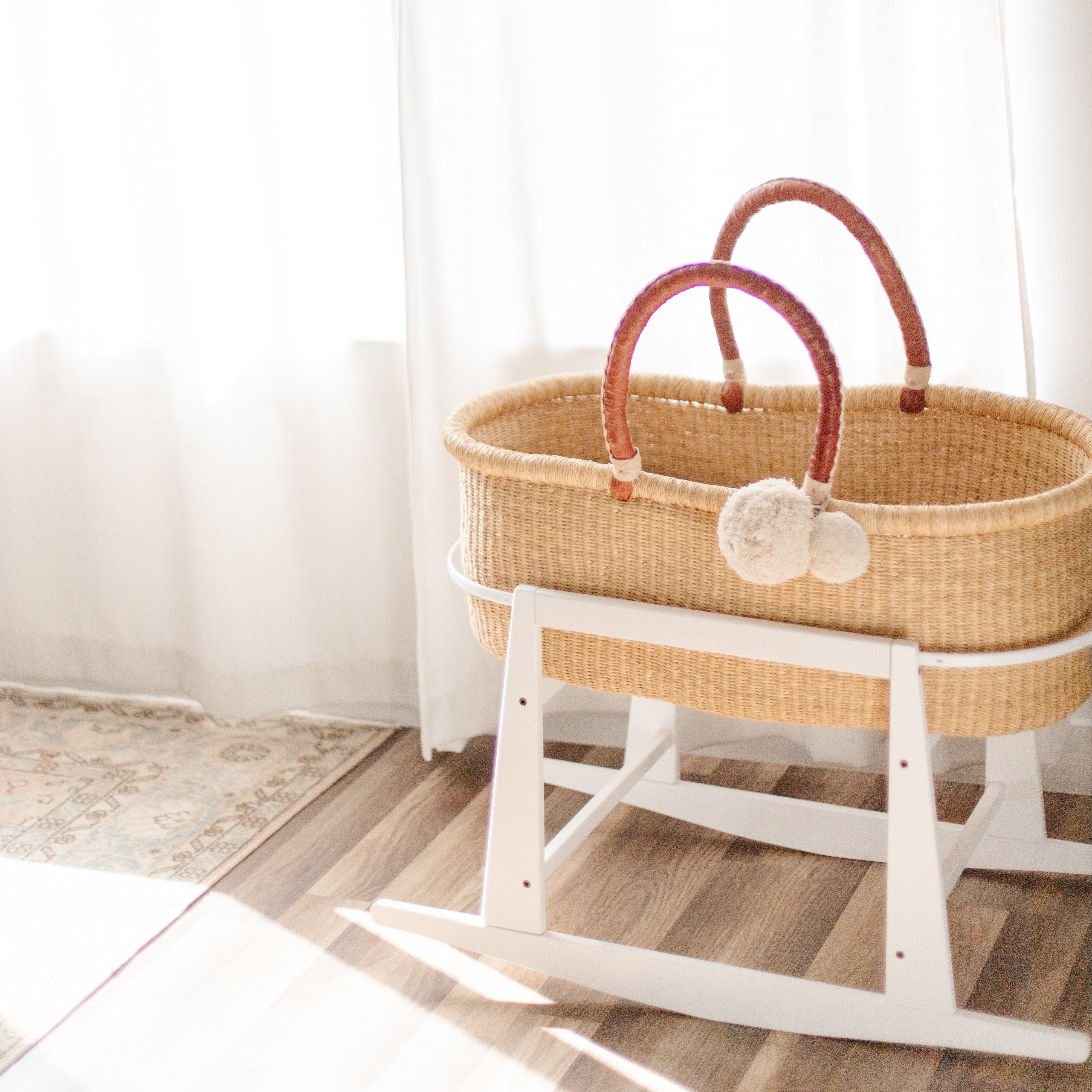 Plum+Sparrow white Moses basket stand with adjustable straps and brake mechanism, close-up detail