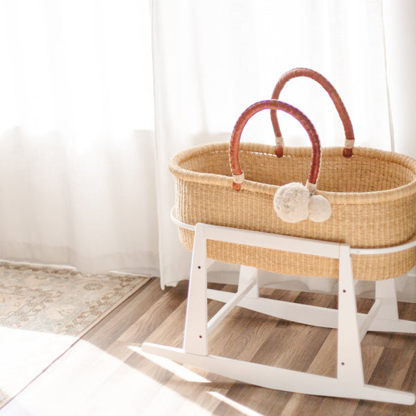 Plum+Sparrow white Moses basket stand with adjustable straps and brake mechanism, close-up detail