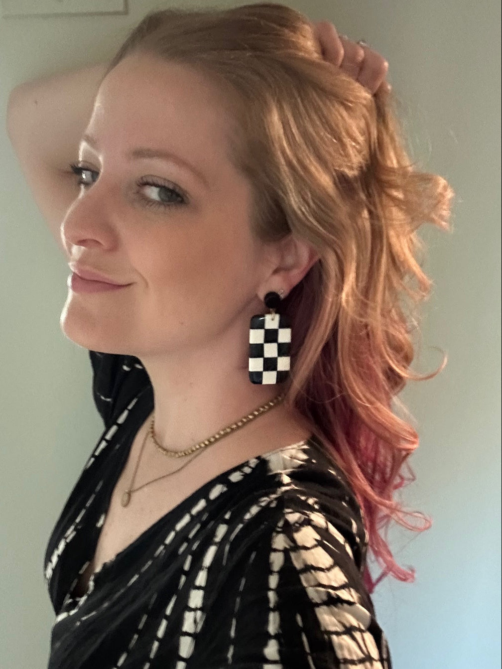 Close-up of Fair Anita checkered resin earrings showing black and white checkerboard pattern detail