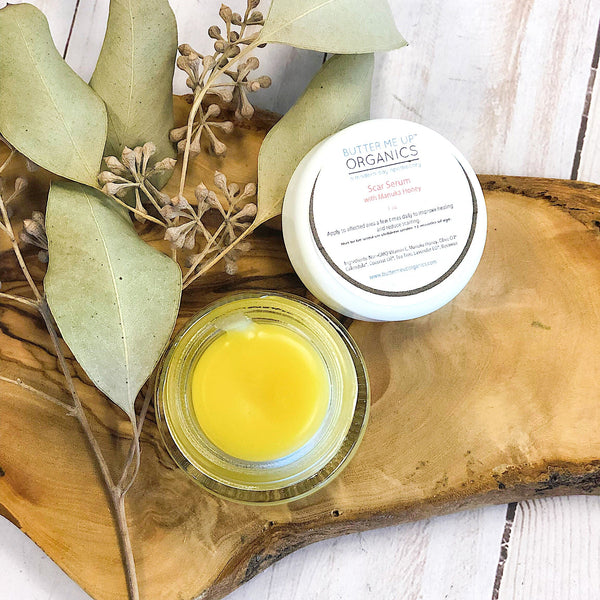Butter Me Up Organics organic scar serum bottle with natural ingredients on neutral background