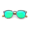 Sunglasses with green lenses and a patterned frame on a white background