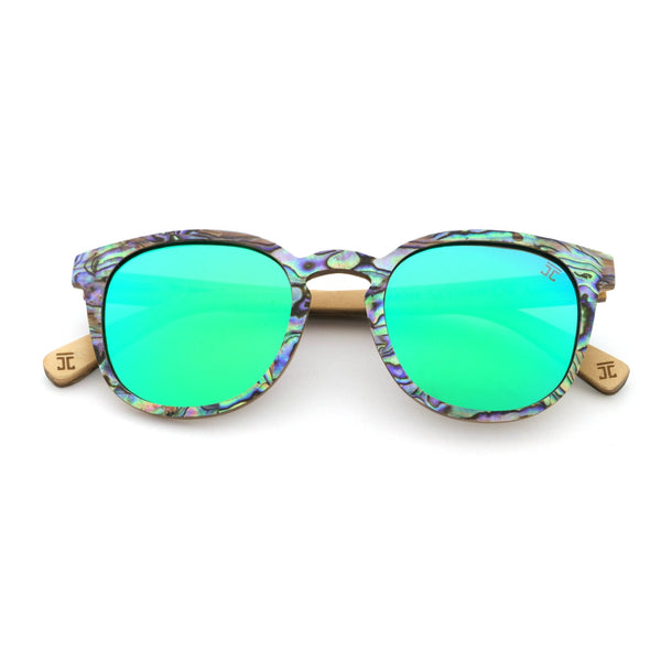 Sunglasses with green lenses and a patterned frame on a white background