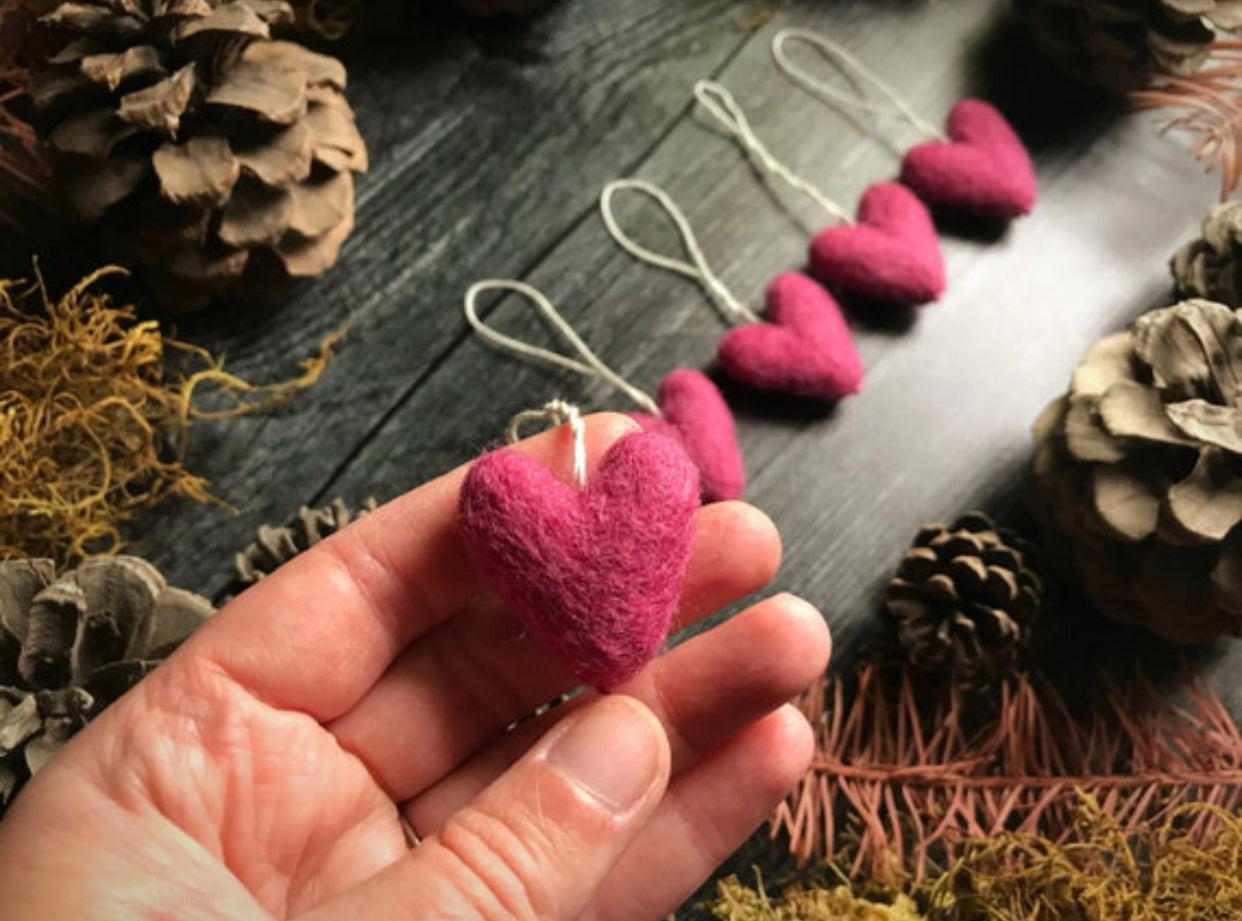 Close view of Wild Rose Pink wool heart ornaments, about 1 inch across