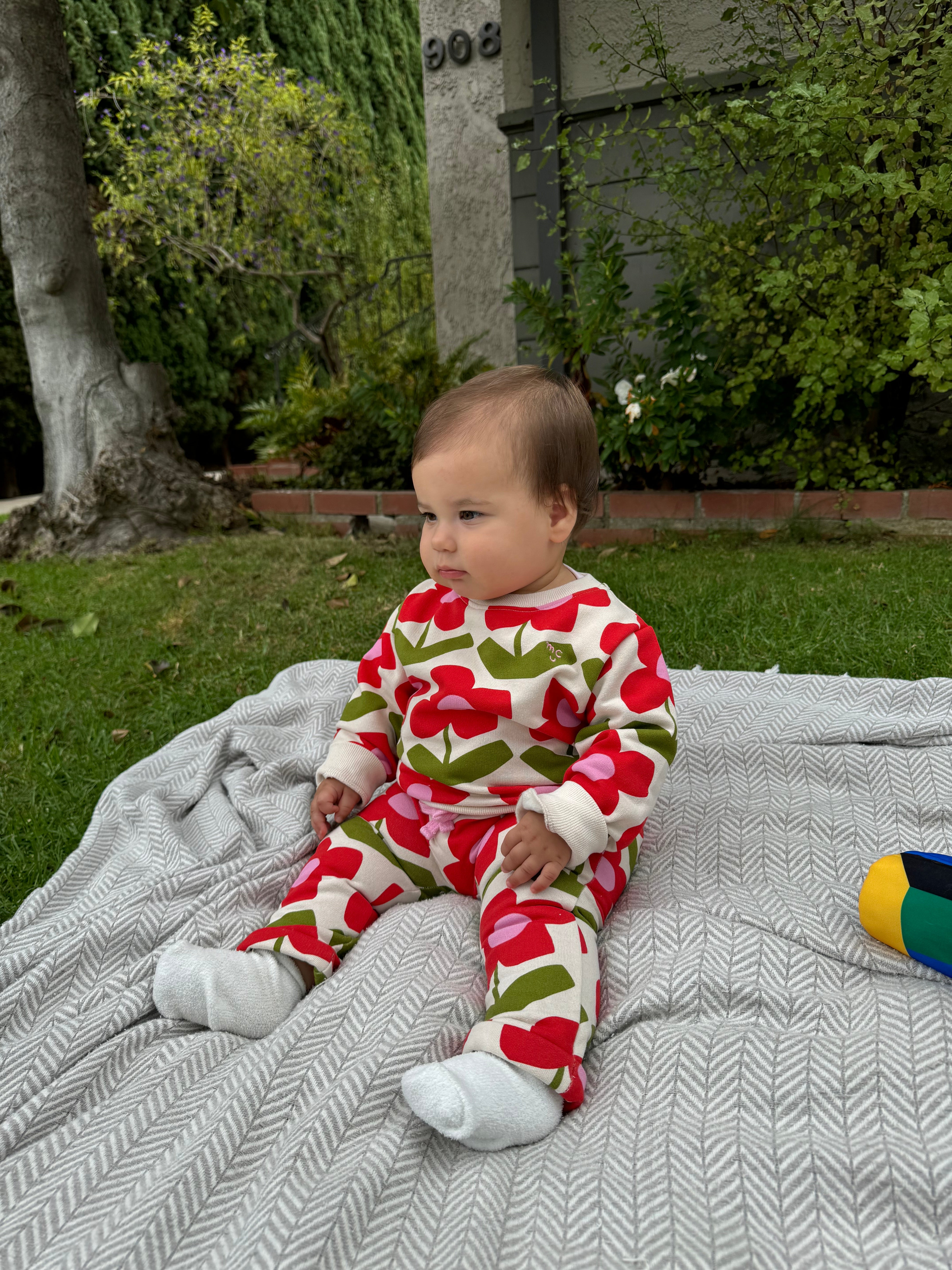 Close-up of Mon Coeur baby sweatshirt floral print and ribbed cuff detail in recycled cotton fleece