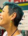 Close-up of Black Swan Winged Earrings worn as an ear climber, nickel-free recycled brass