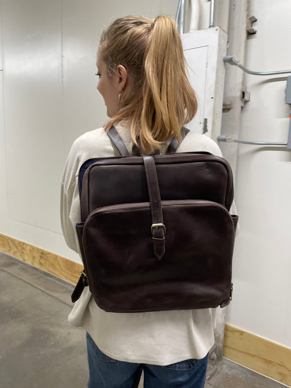 Person wearing a brown backpack in an indoor setting