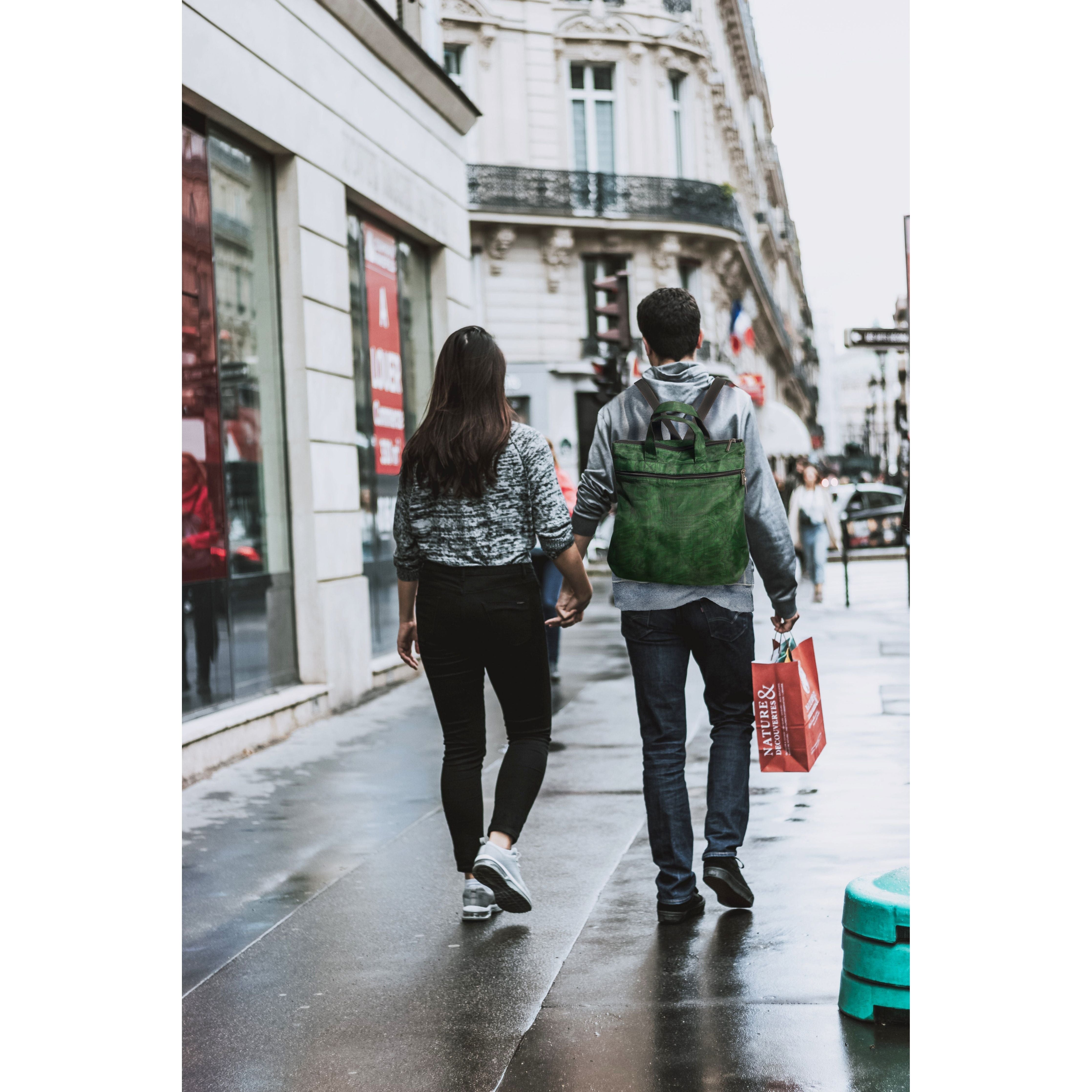 Two people walking down a city street on a rainy day.