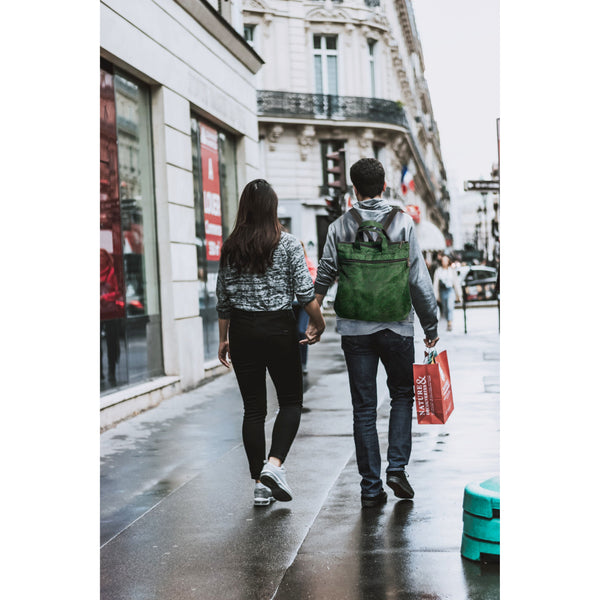 Two people walking down a city street on a rainy day.