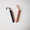 Black and rose gold carabiner clips on a white background