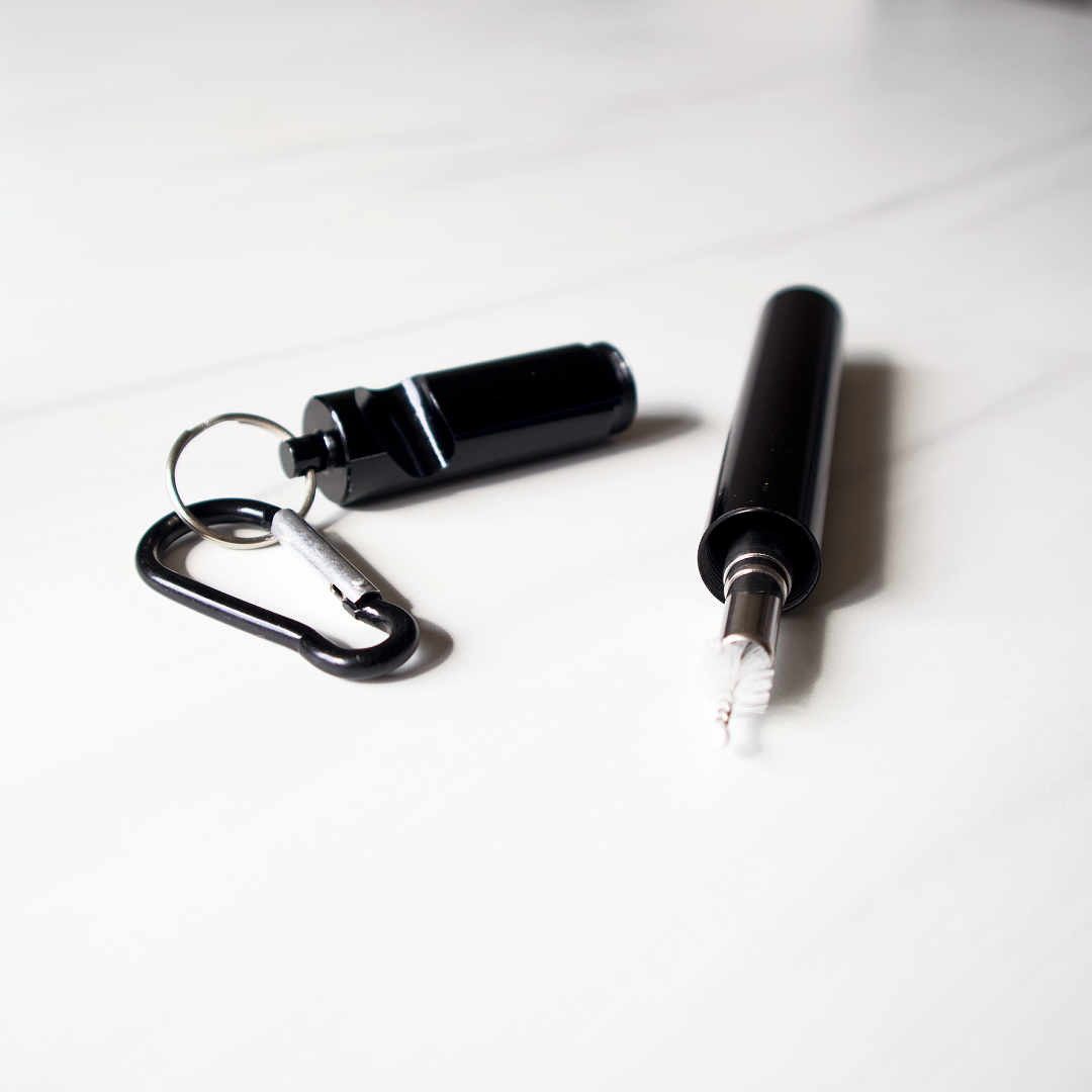 Black pepper spray with carabiner and white marker on a white background