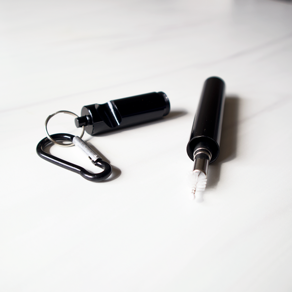 Black pepper spray with carabiner and white marker on a white background