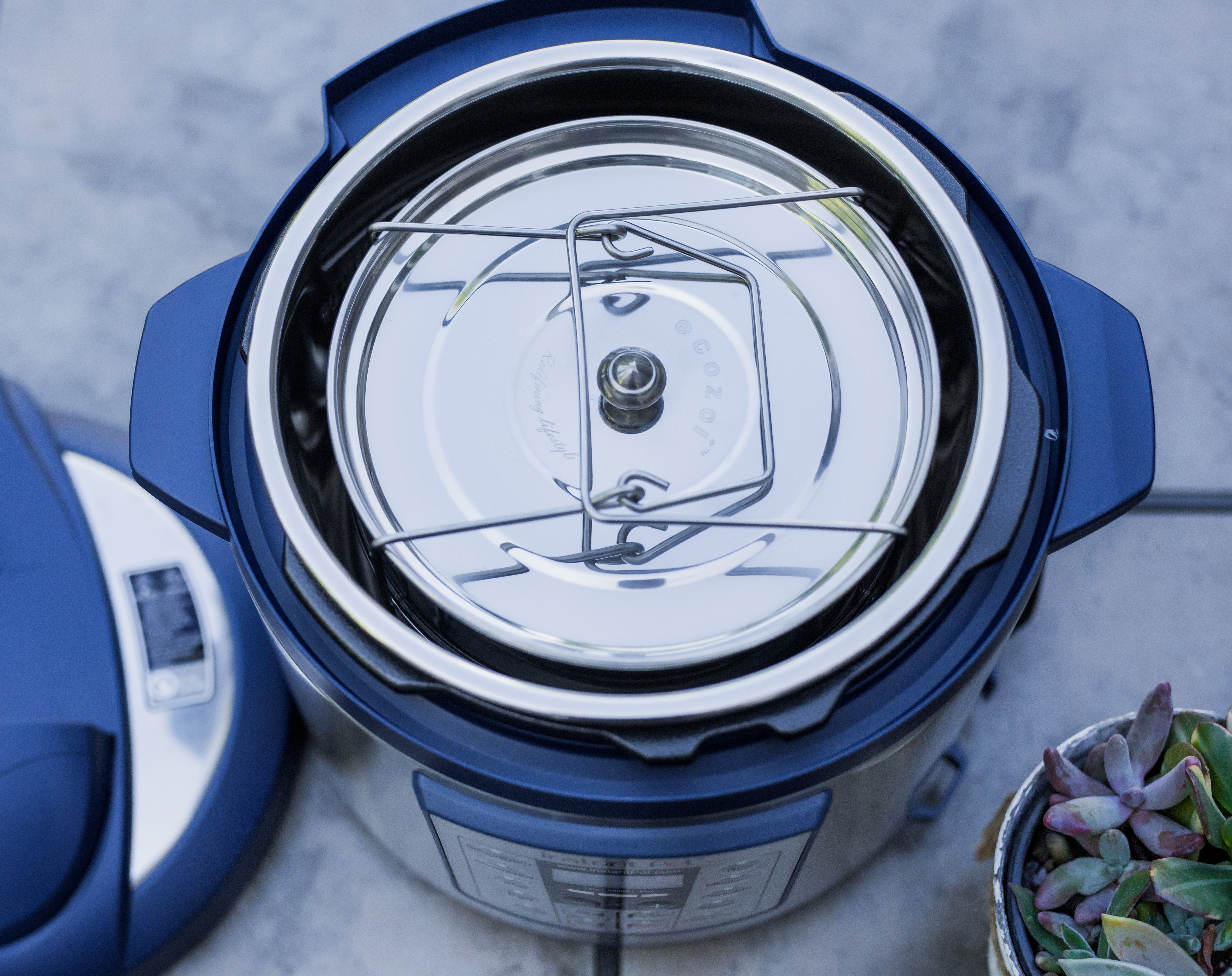 Close-up of a blue and white pressure cooker with a blurred background