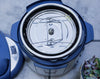 Close-up of a blue and white pressure cooker with a blurred background