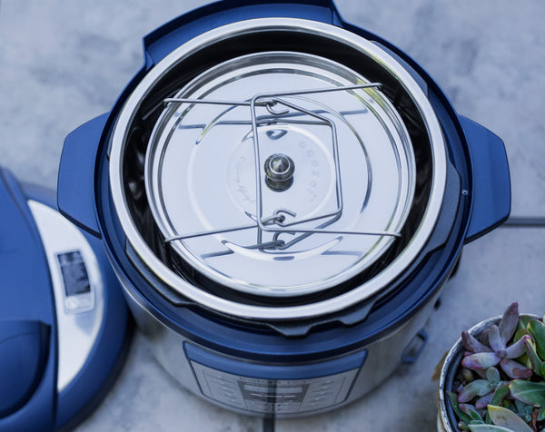 Close-up of a blue and white pressure cooker with a blurred background