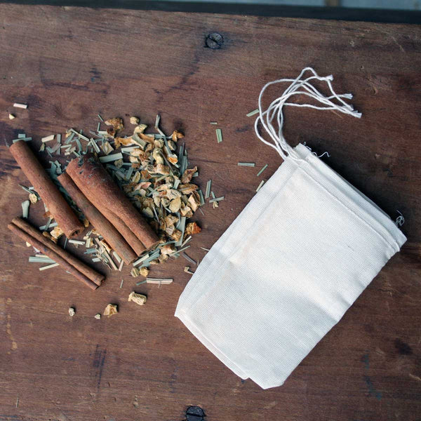 A high-quality photograph of the Lemon Ginger Hot Toddy Kit, showcasing its rustic packaging and the individual spice blends.