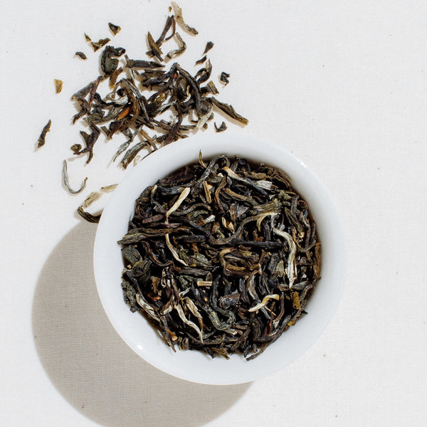 Loose-leaf Jasmine Reserve organic green tea by Art of Tea displayed in a small white bowl on a clean white background, showing the delicate dried tea leaves