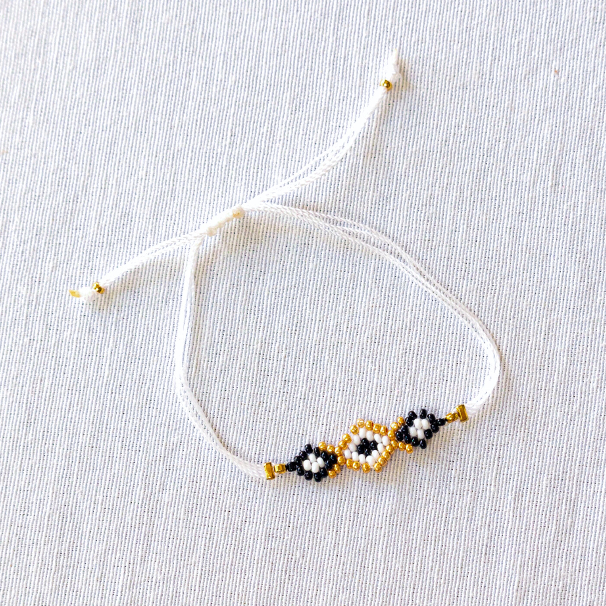 Beaded bracelet with geometric pattern on a light gray background