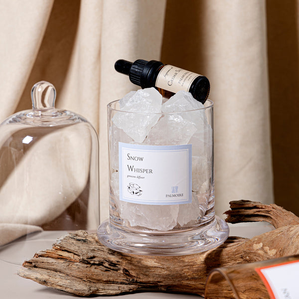Glass container with ice and 'Snow Whisper' label on a wooden surface with a blurred background