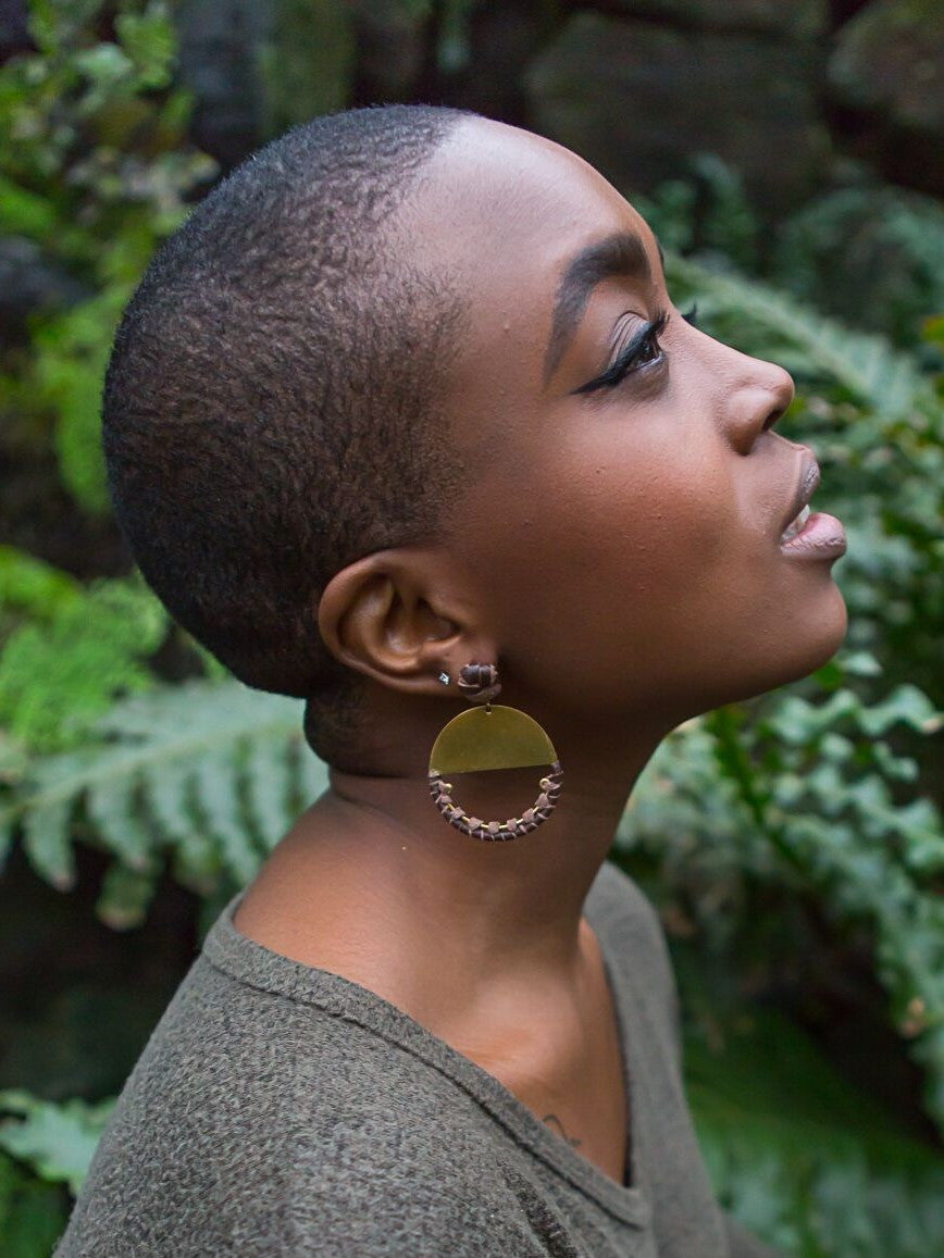 Close-up of Fair Anita leather and brass loop earrings showing knotted leather texture