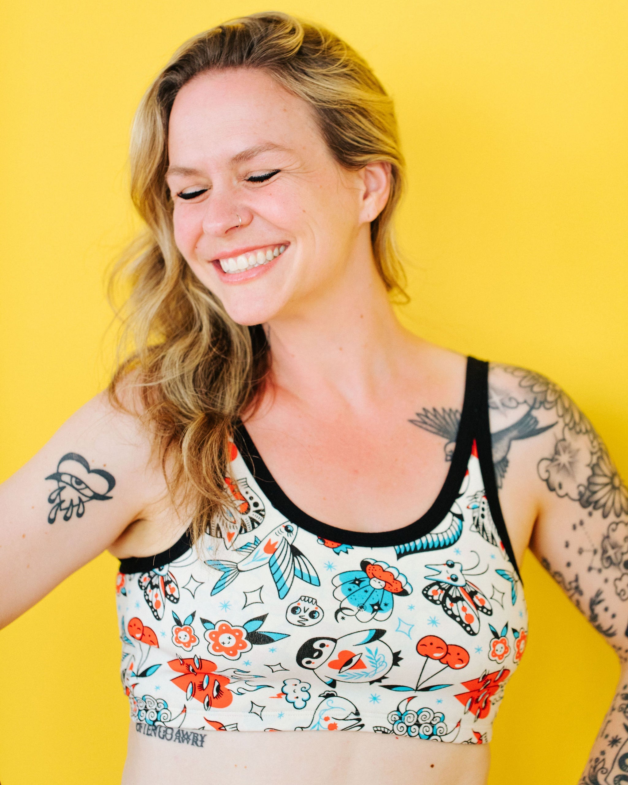Woman wearing Thunderpants Inked Up Longline Bra featuring whimsical tattoo print characters