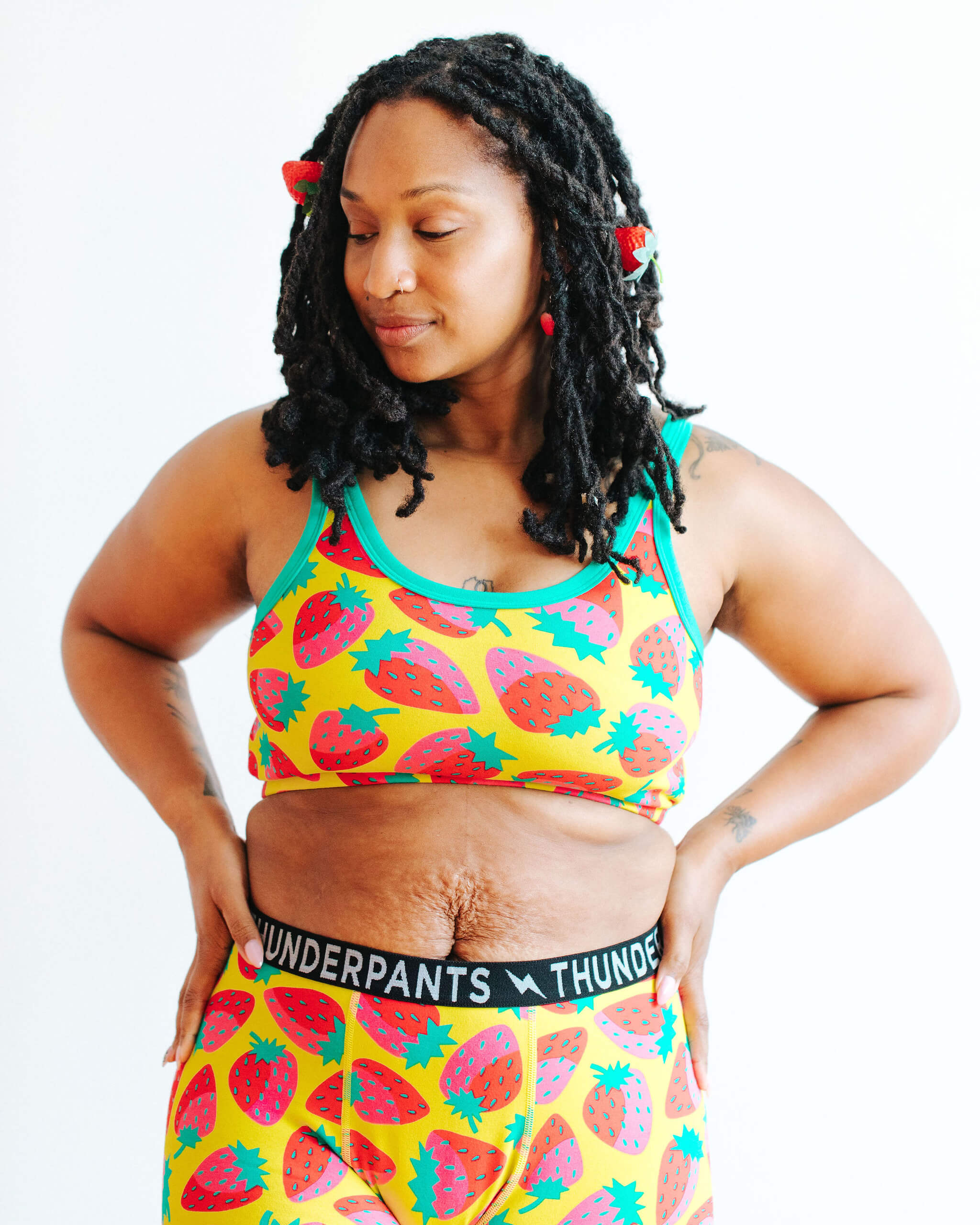 Woman wearing a colorful sports bra and shorts set with 'Thunderpants' waistband.