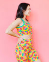 Woman wearing a colorful strawberry pattern outfit against a pink background