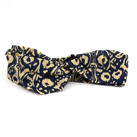 Navy and beige patterned headband on a white background
