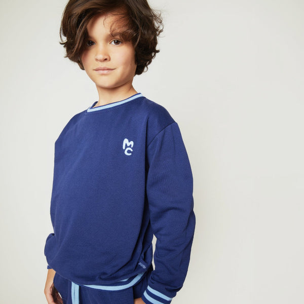 Child wearing the Mon Coeur MC Navy Sweatshirt with striped rib trim at collar and cuffs