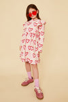 Child in Mon Coeur sustainable heart print kids dress styled for cool weather