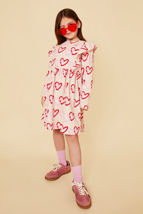 Child in Mon Coeur sustainable heart print kids dress styled for cool weather