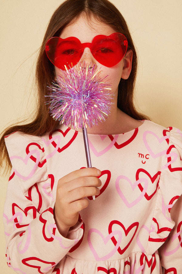 Girl wearing Mon Coeur long sleeve heart print ruffle dress with high-waist flared skirt