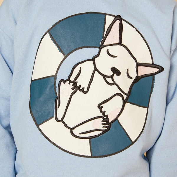 Light blue sweatshirt with a circular design of a white cat on a blue background