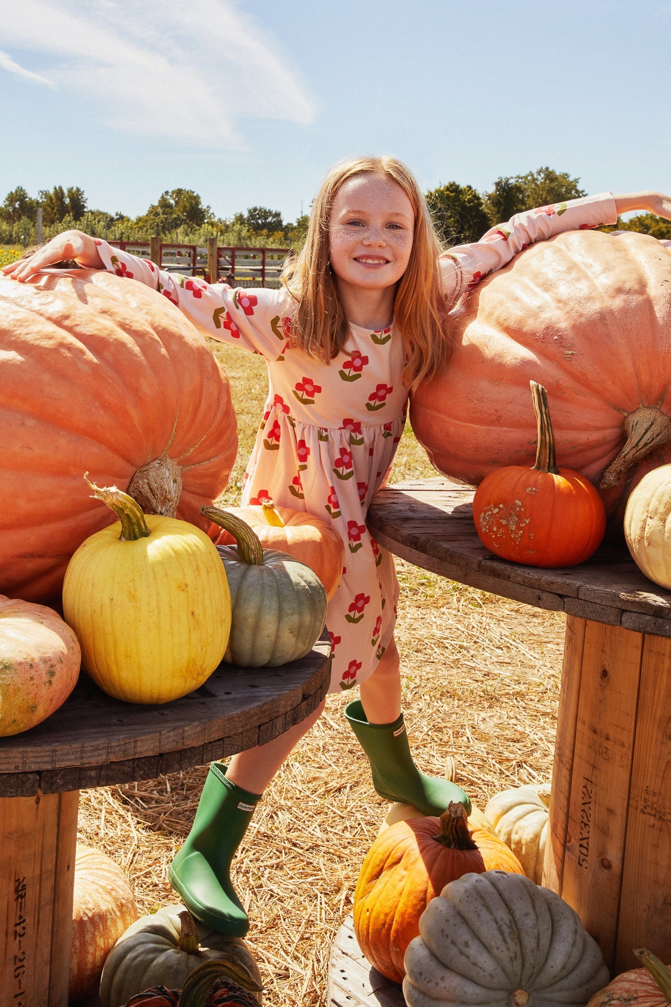 Young girl standing among pumpkins at a pumpkin patch