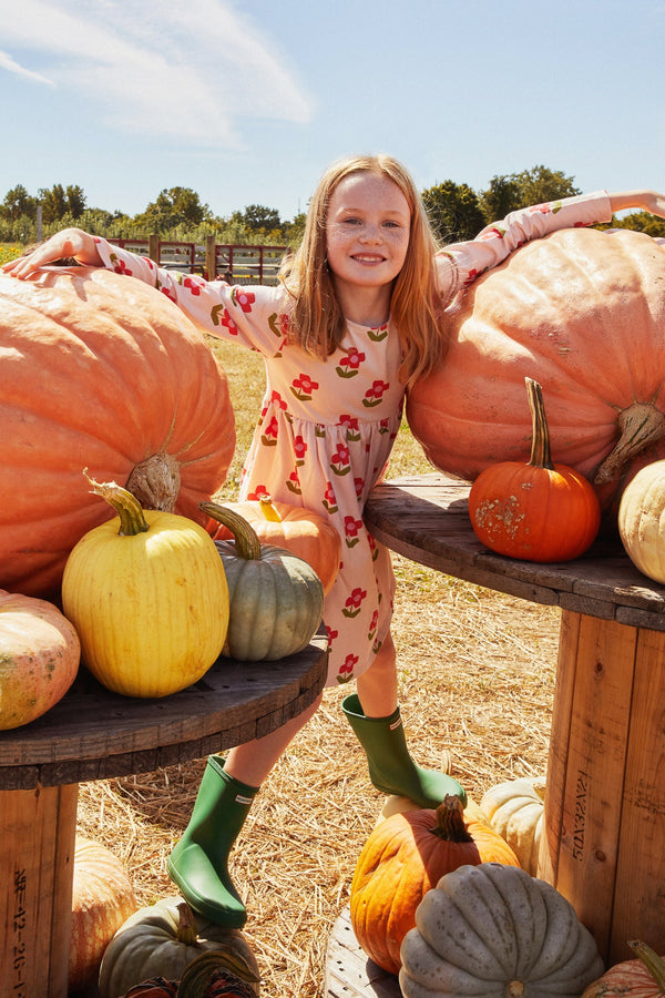 Young girl standing among pumpkins at a pumpkin patch