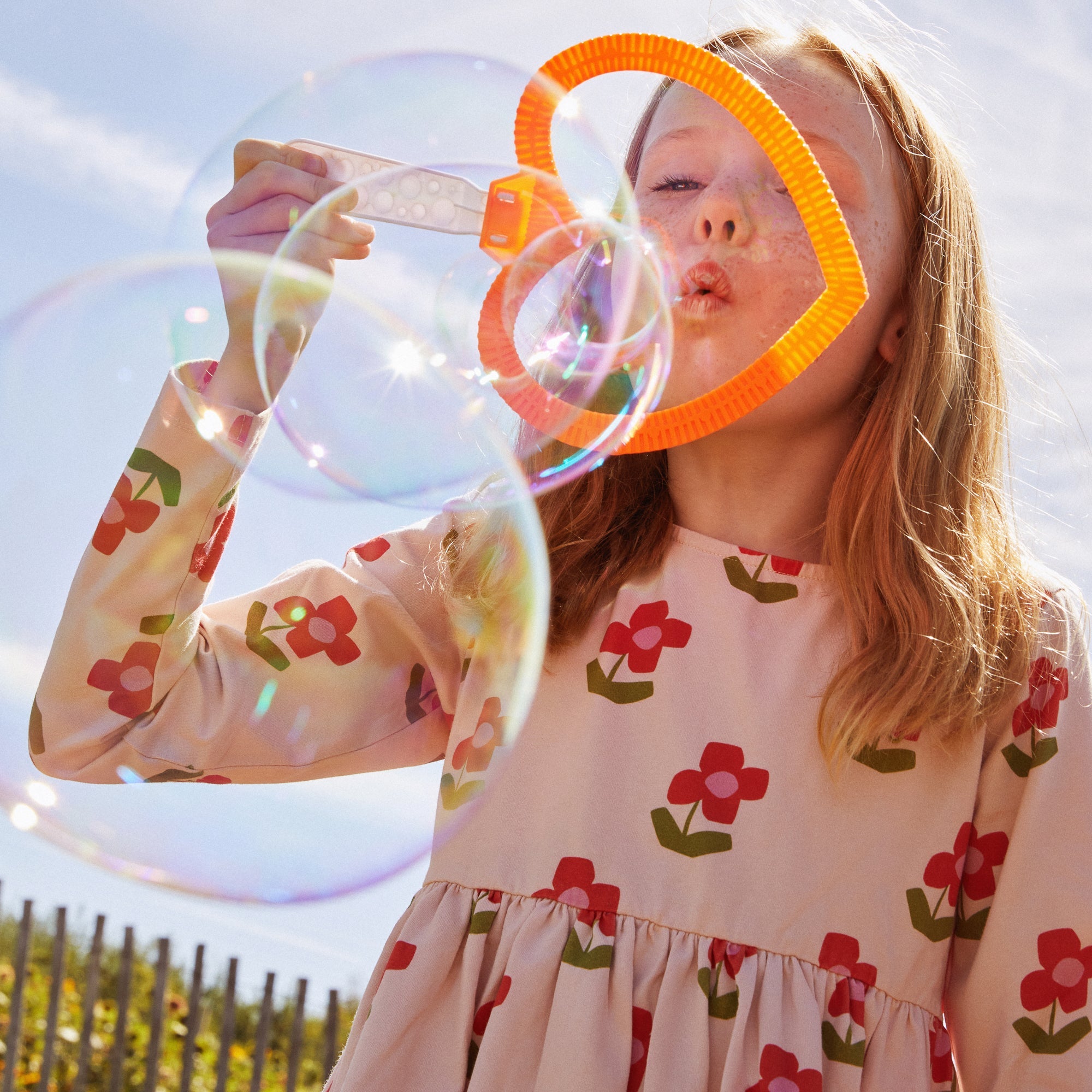 Child wearing organic cotton floral jersey dress with button-back detail