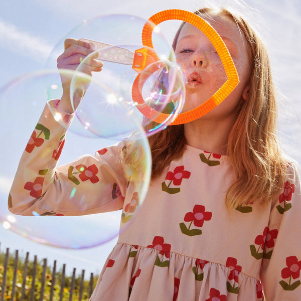 Child wearing organic cotton floral jersey dress with button-back detail