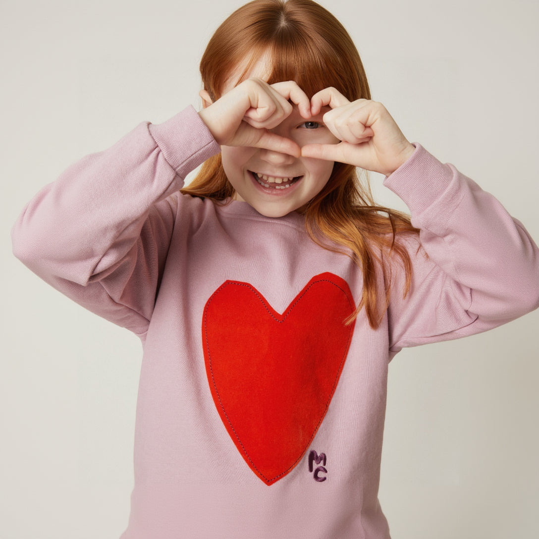 Child wearing Mon Coeur Heartfelt Sweatshirt, a sustainable kids' sweatshirt with heart detail