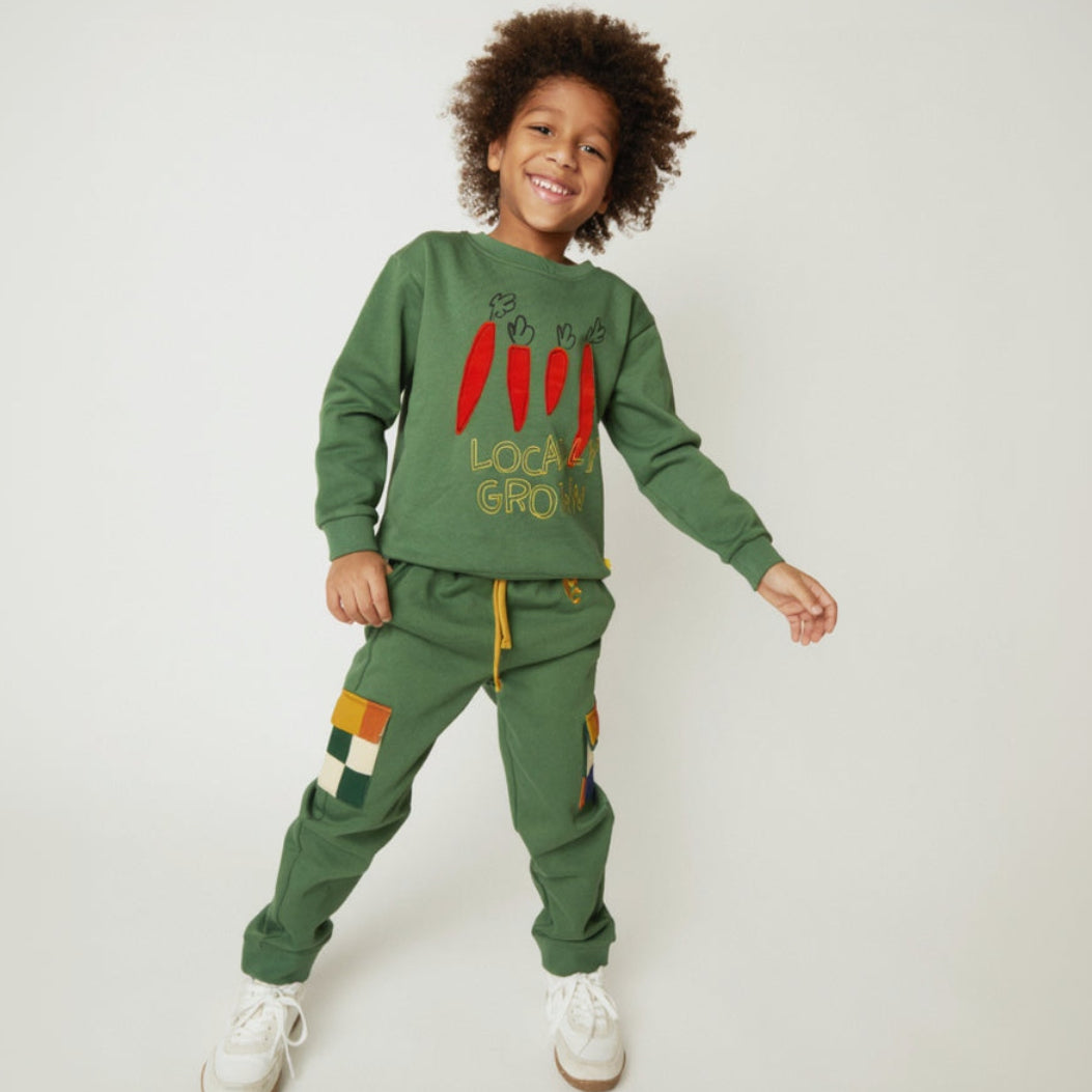 Mon Coeur kids green jogger pants with checkered pockets, styled on a child