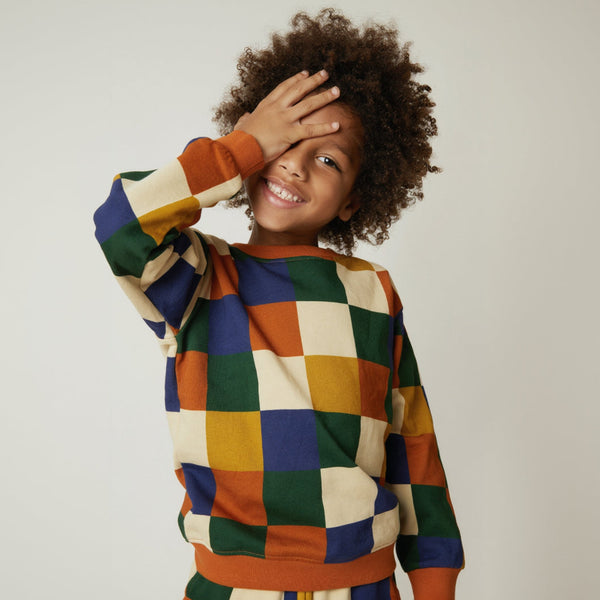 Child wearing Mon Coeur Fall Checkered Sweatshirt in bold checker graphic print, available in sizes 1Y to 12Y