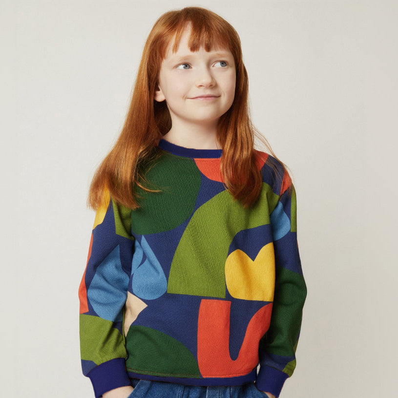 Child wearing the Mon Coeur Fall Shapes Sweatshirt, a sustainable kids' sweatshirt with a bold fall print