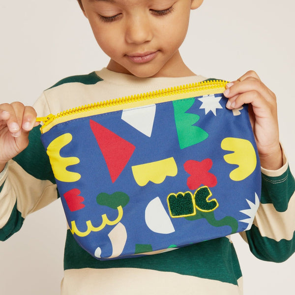 Child holding a colorful geometric-patterned pouch